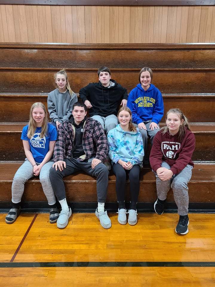 7 high school students sitting on bleachers