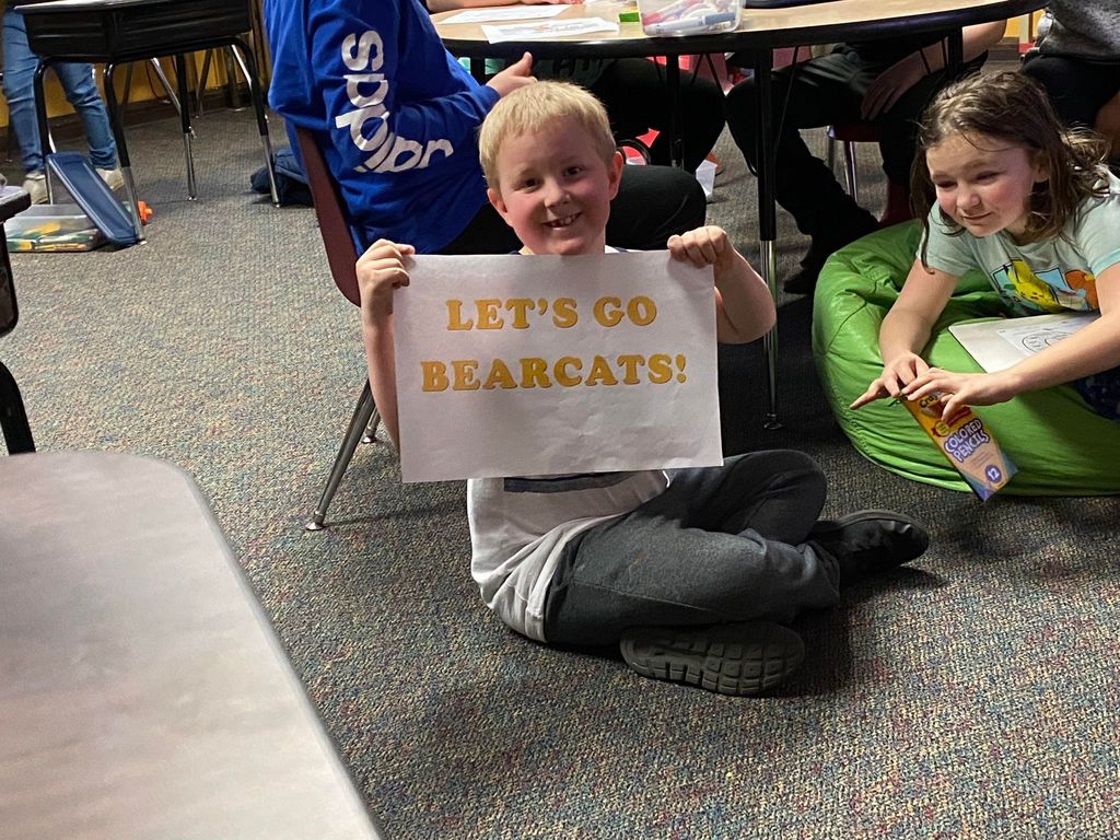 Student with Let's Go Bearcats sign