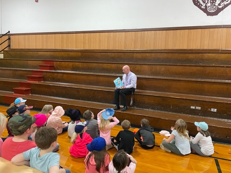1st grade students being read to by Principal Leberman.