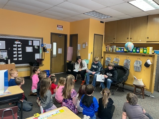 Three German students reading to the 1st grade class.
