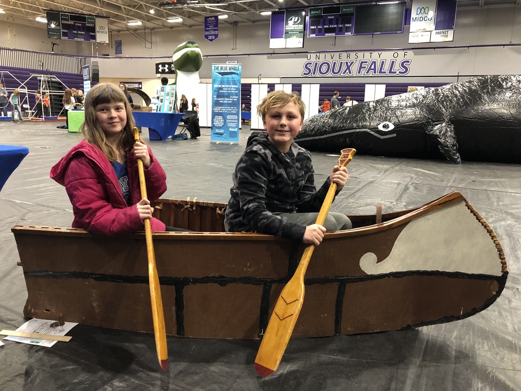 2 students with oars in pretend canoe