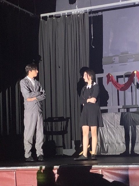 Boy and girl on stage in costume.