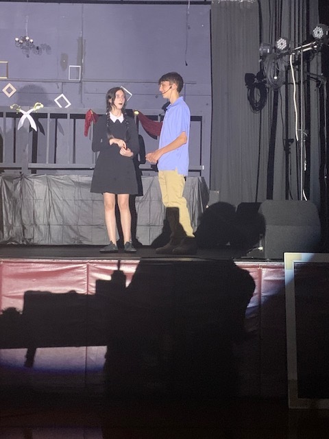 Two students on stage in costume.